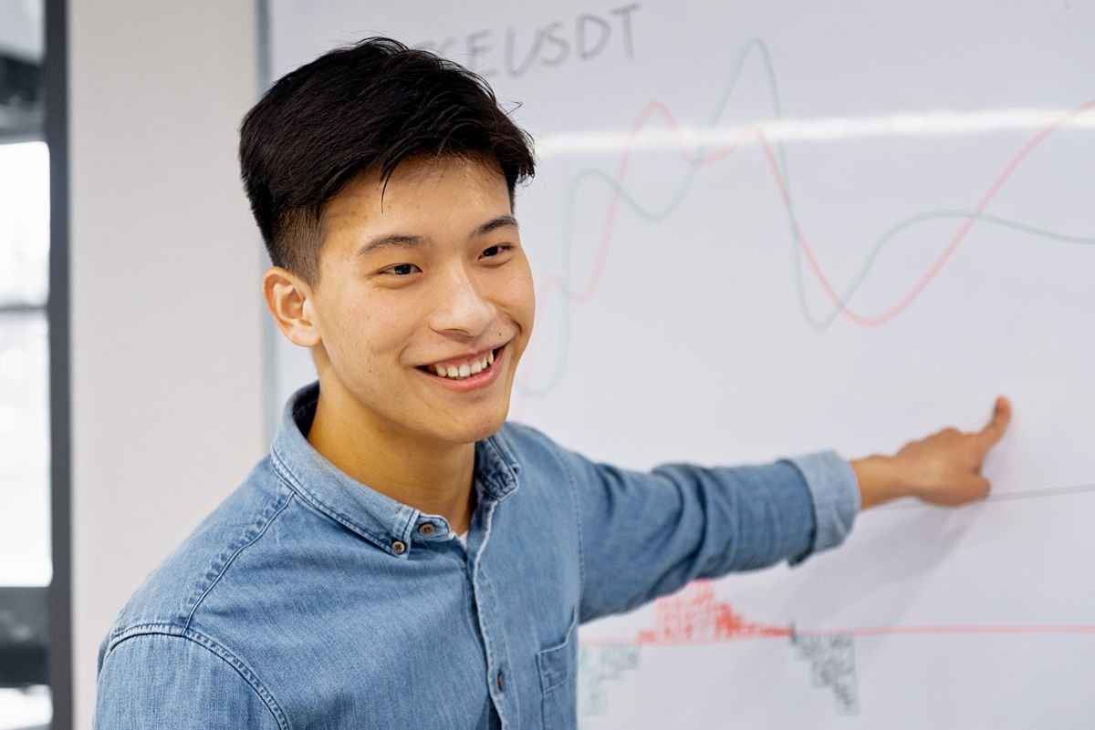 A smiling participant presenting insights at a whiteboard