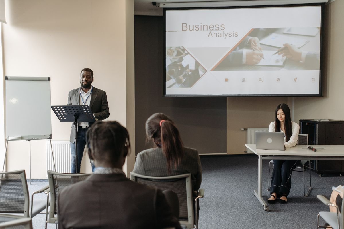 A speaker leading a business analysis seminar with an engaged audience